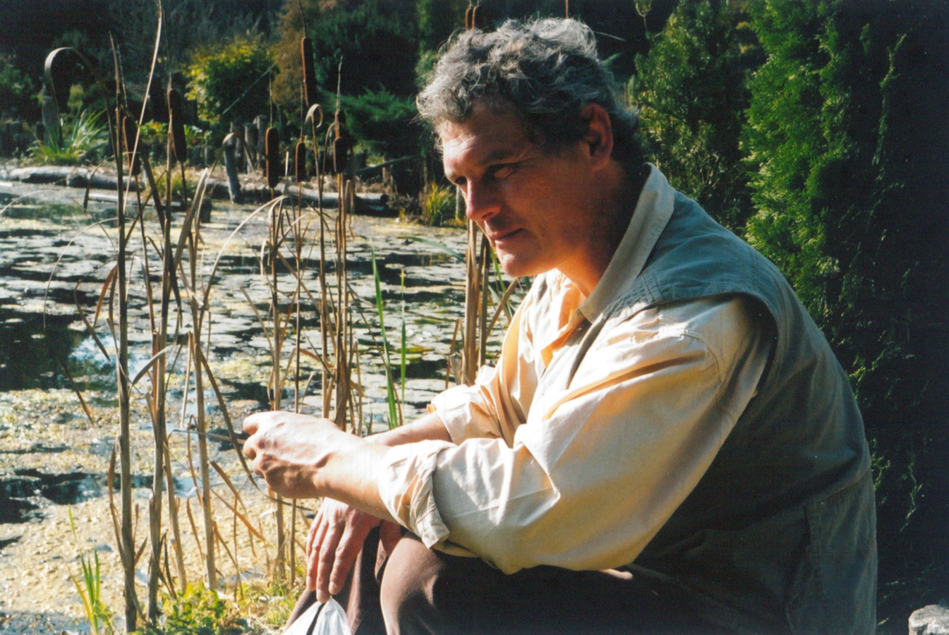 Mężczyzna siedzący obok stawu