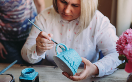 Adobe Stock zdjęcie kobiety malującej filiżankę niebieską farbą